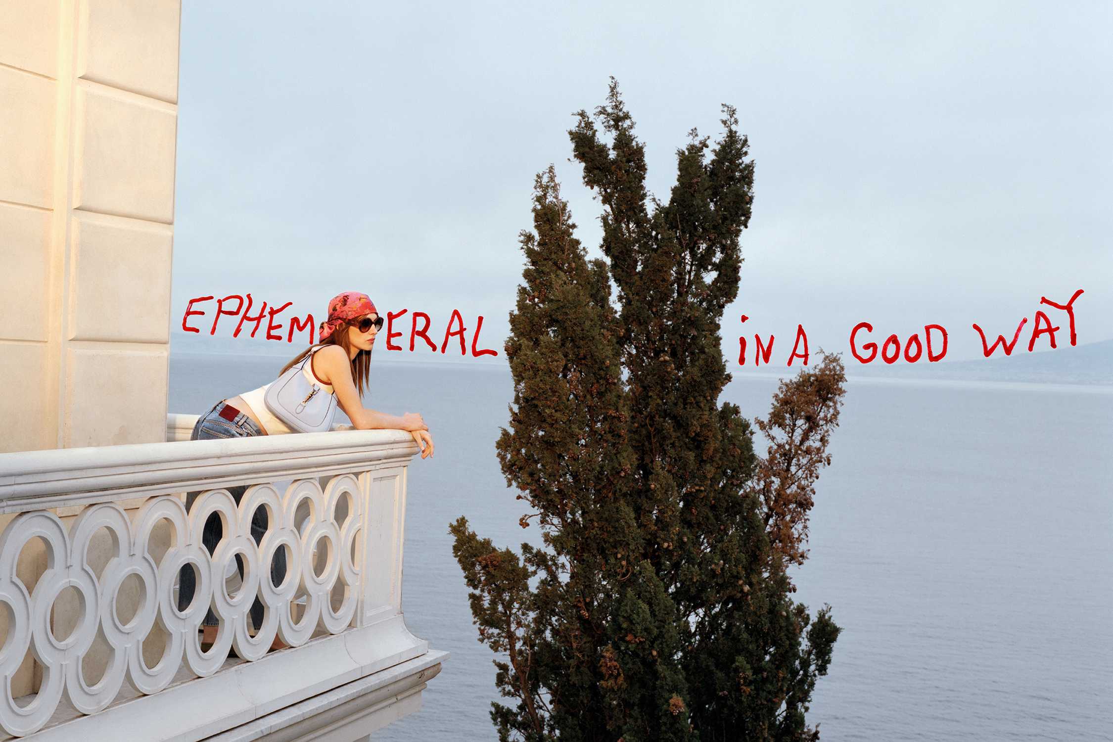 Person overlooking sea from balcony