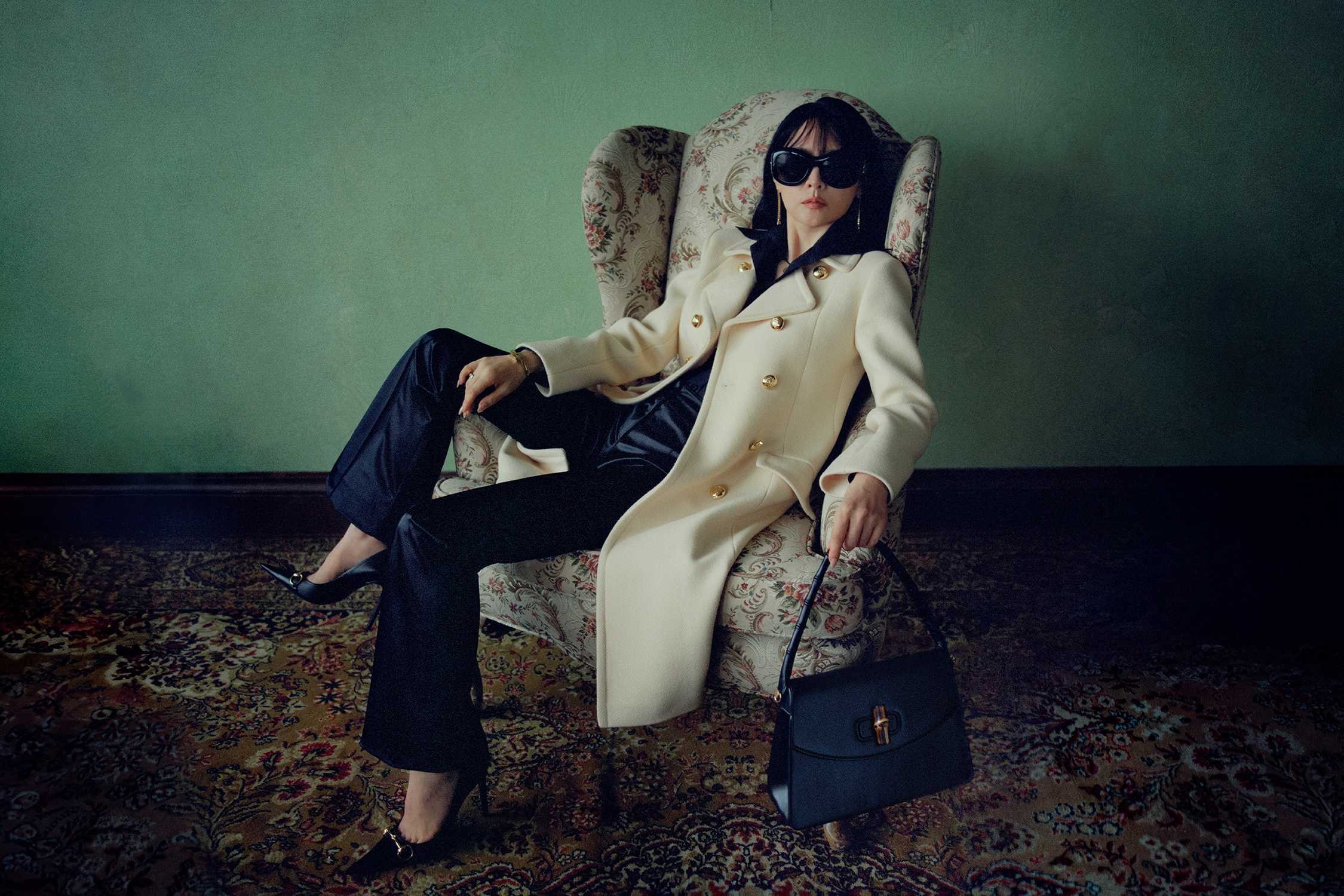 Cream coat, navy blue bag.