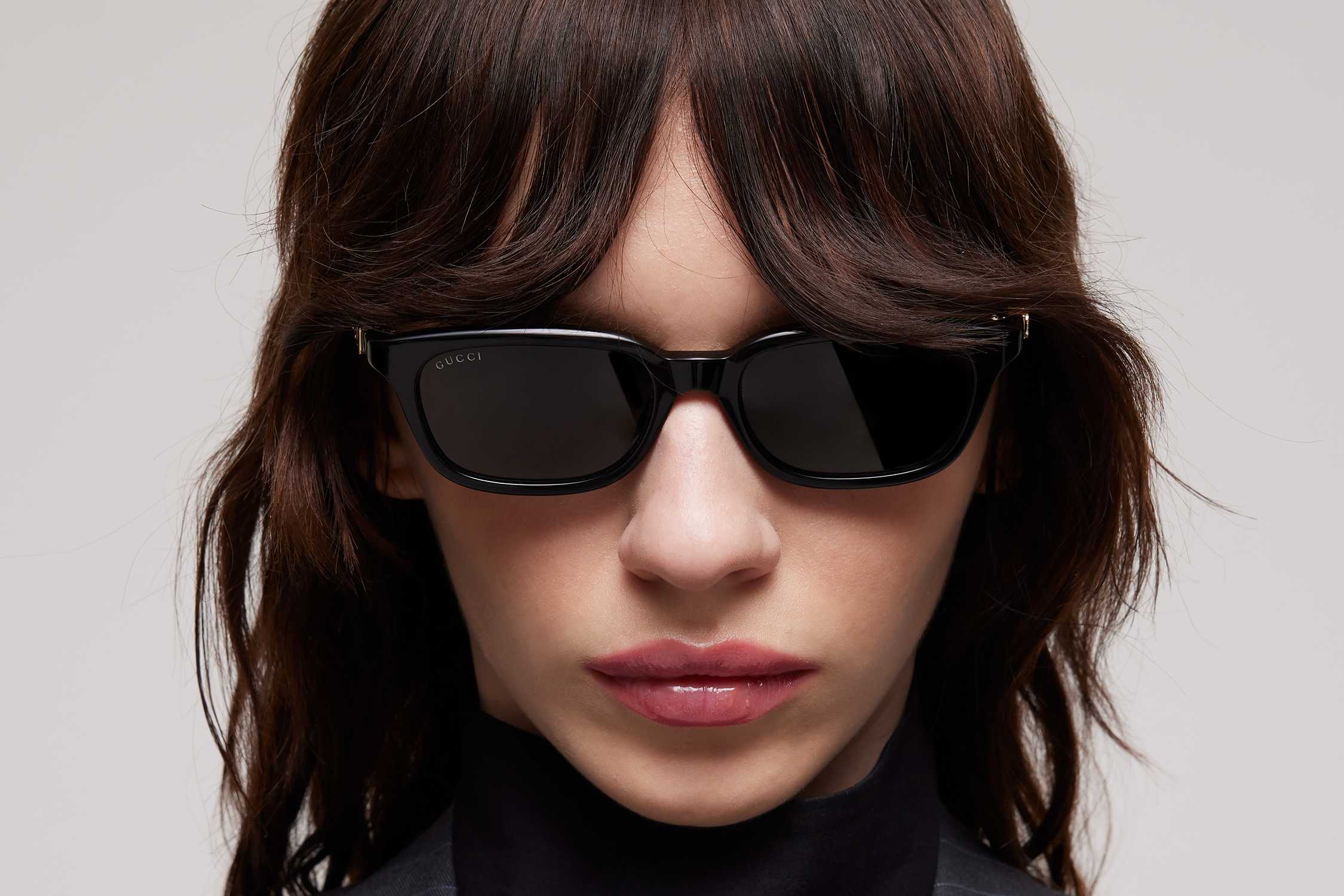 Black Gucci rectangular sunglasses worn.
