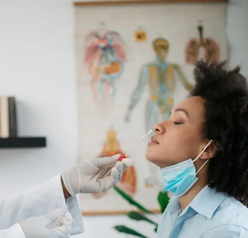 Doctor takes a swab sample from a female patient's nose.