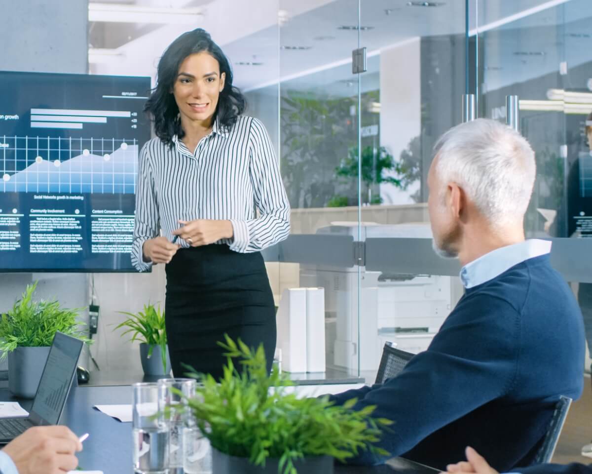 Finance professional presents charts to colleagues in a conference room