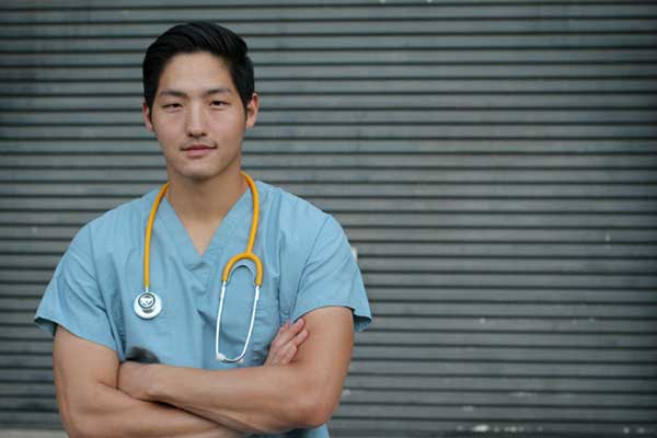 Male Nurse standing against a wall