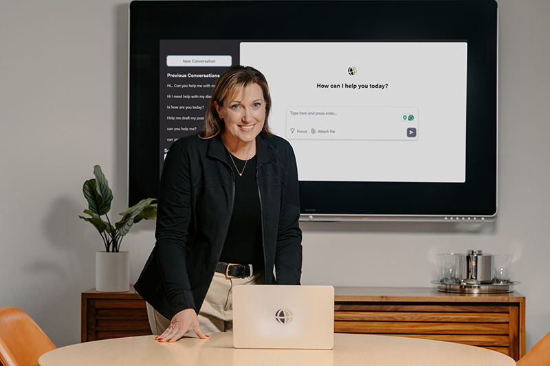 Judy Lewandowski standing at a table in a conference room with a laptop with a Purdue Global logo