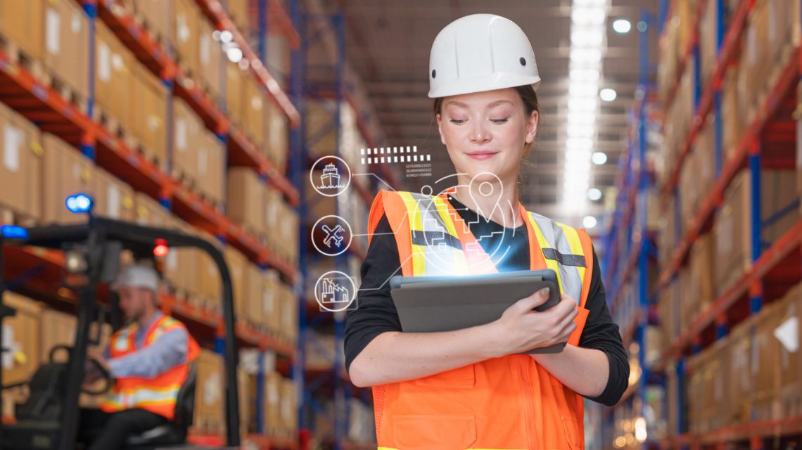 A warehouse worker reviewing information on her tablet.