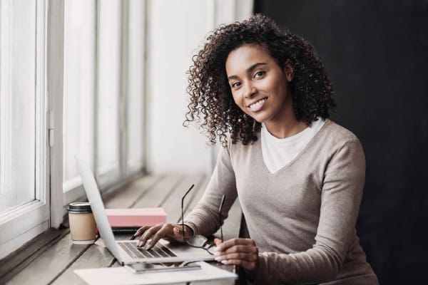 A woman works on her computer as she pursues an MBA in information technology.