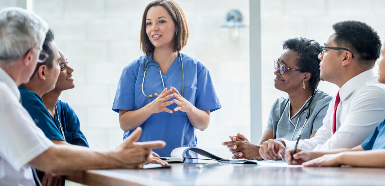 A nurse talks to a group of health care workers.