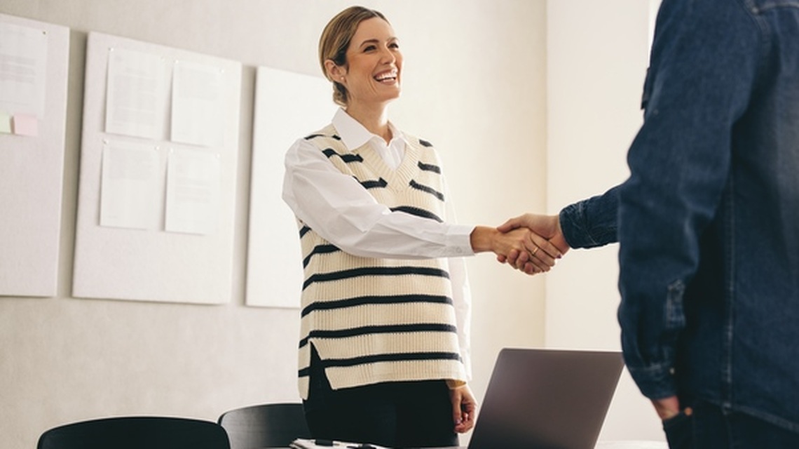 An HR professional shaking a colleague's hand.