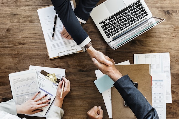 Two people shaking hands over a table