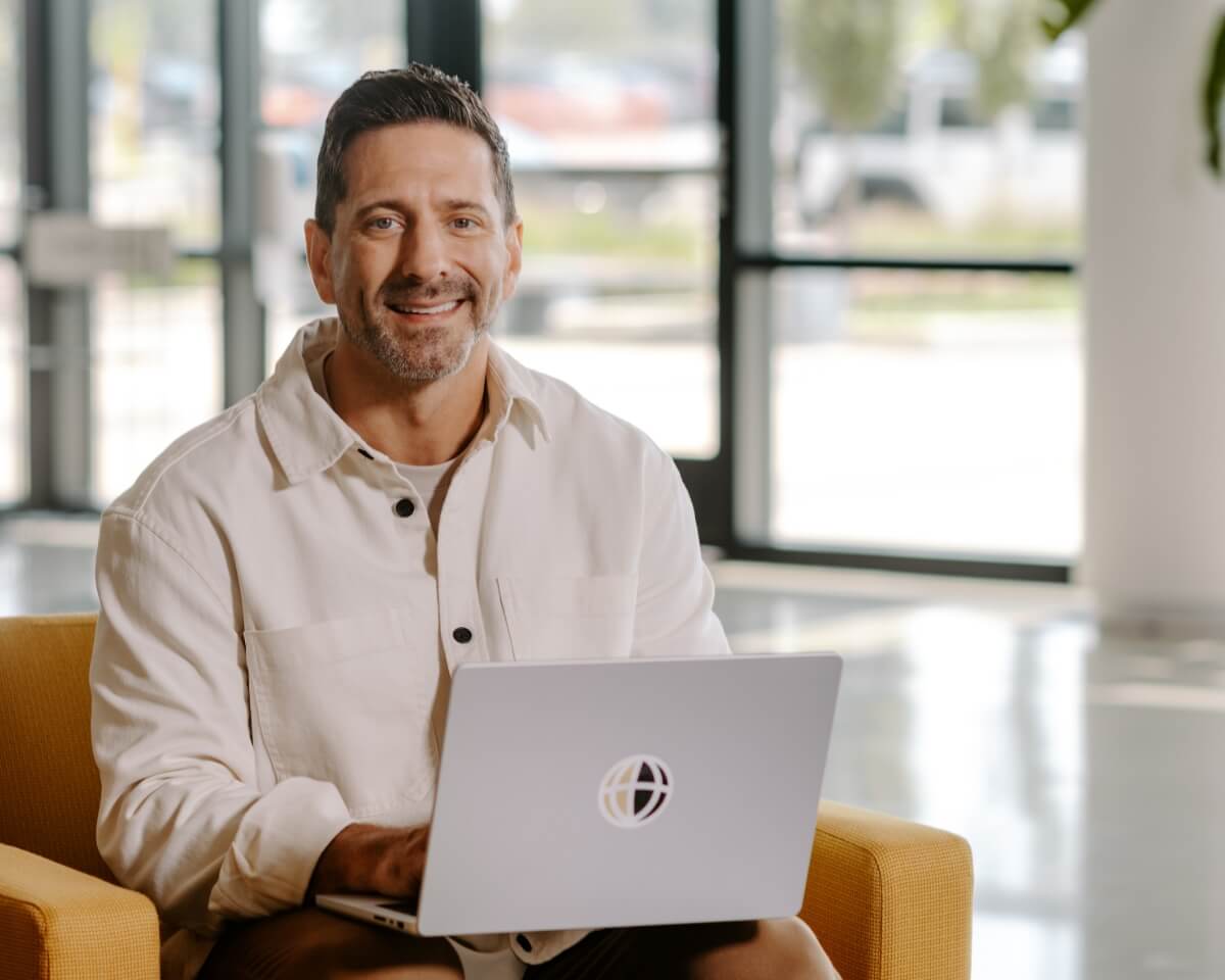 Student working on a laptop with a Purdue Global logo in a building lobby