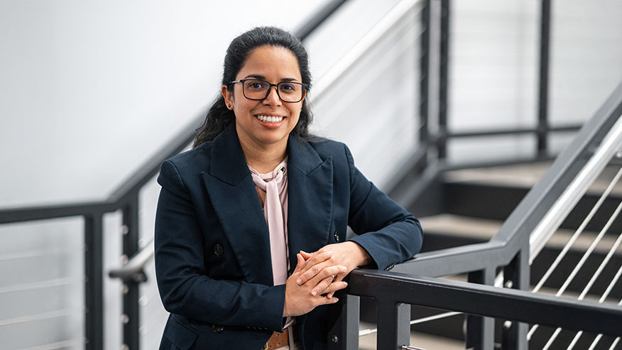 Maricel Lawrence in a blue jacket next to a staircase.