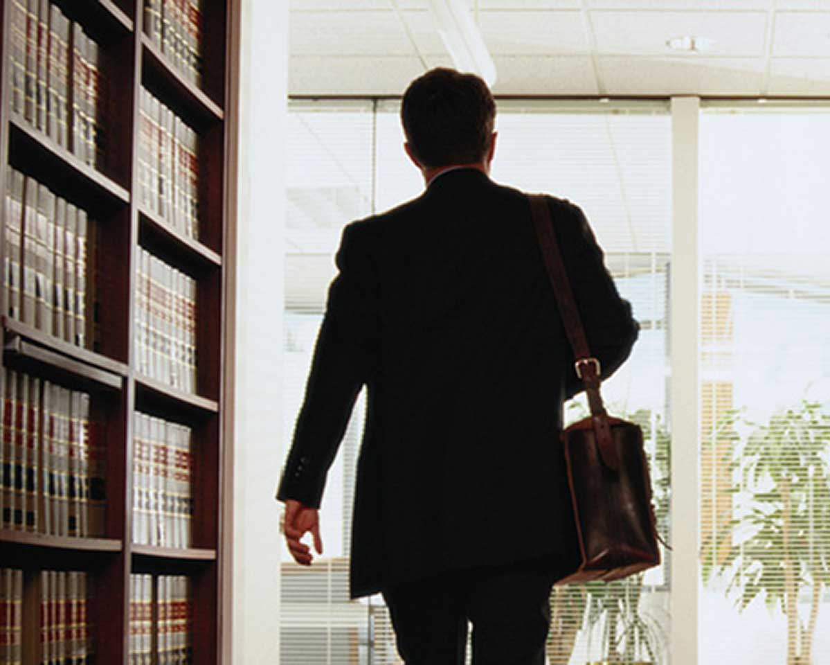 Man carrying a briefcase and walking toward the exit of a law library