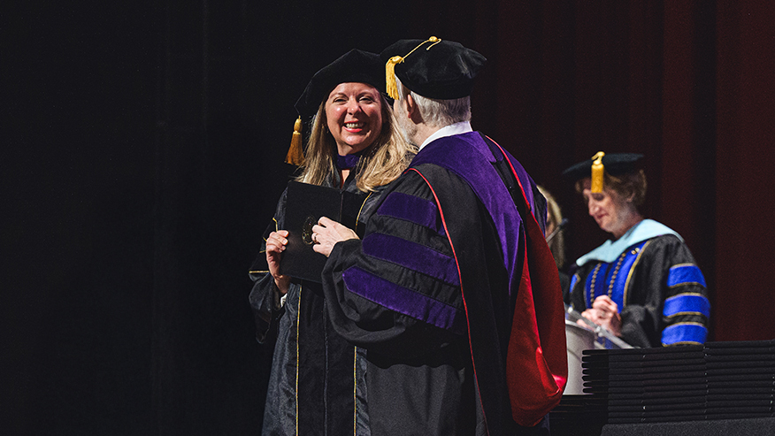 Purdue Global graduate Abigail Strehle receives her law degree from Purdue Global Law School Dean Martin Pritikin at the October 2023 commencement ceremony
