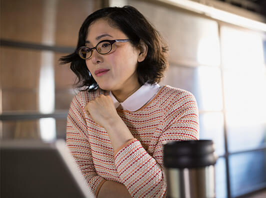 Law student on laptop with coffee tumbler on table