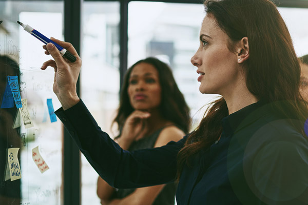 A woman points at a whiteboard