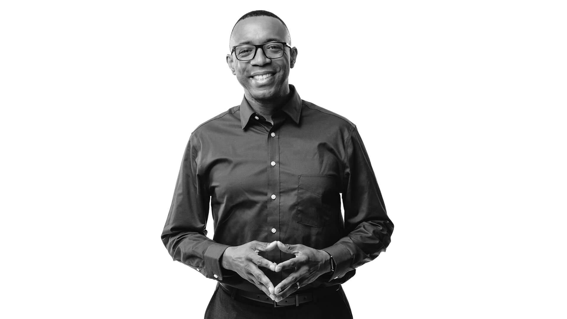 Alan Thomas is smiling at the camera in a professional, black and white photo.