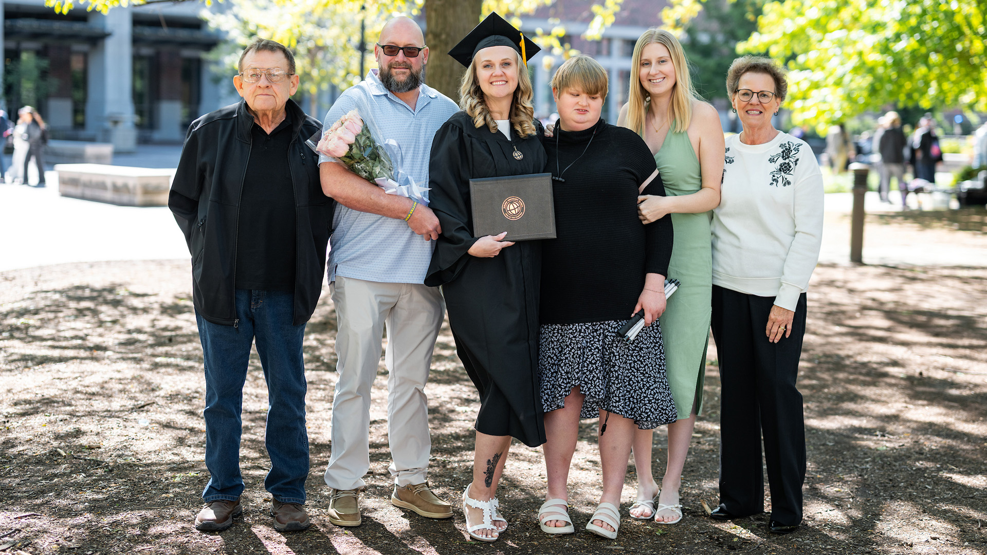 Angel Riley is pictured at graduation with her parents, her kids and her husband.