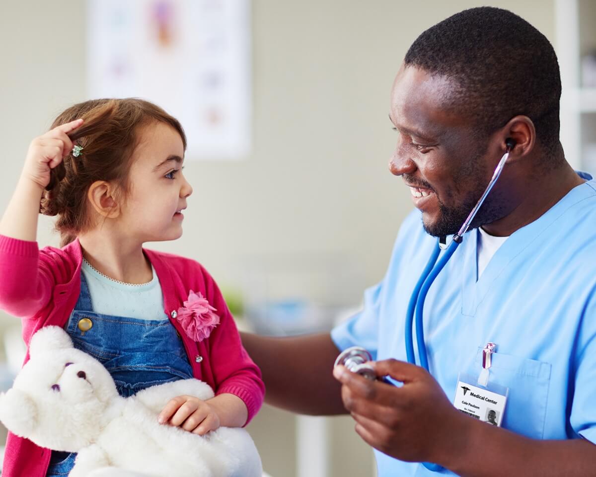 Nurse with a stethoscope examining a little girl