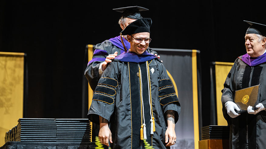 Purdue Global Law School graduate Stefan May is hooded during the October 2025 commencement ceremony.