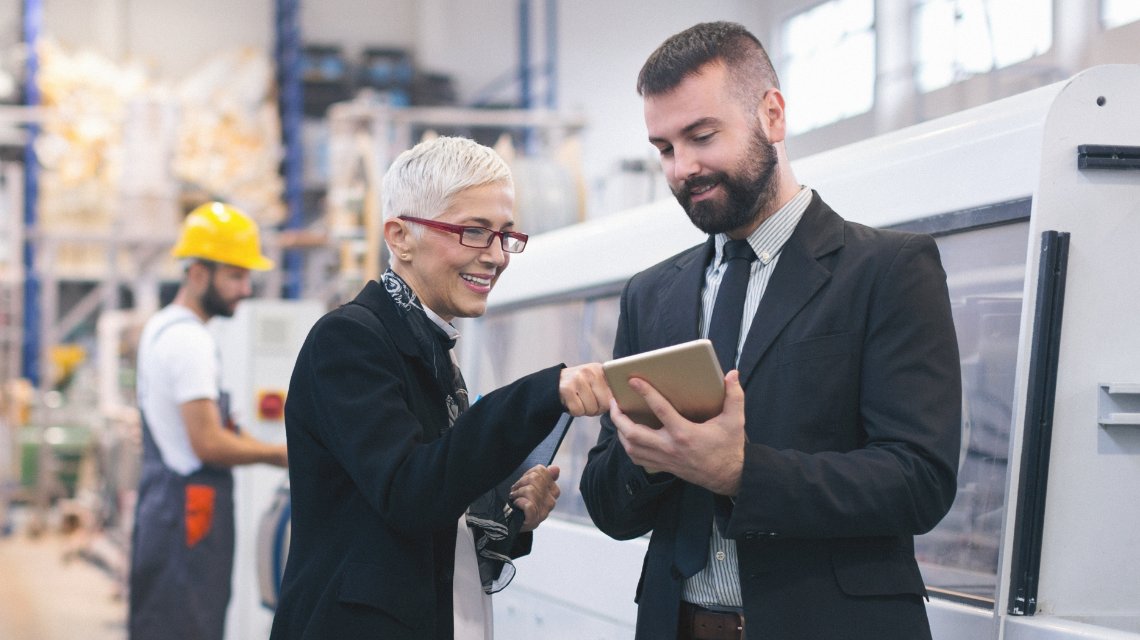 Two colleagues reviewing data in a warehouse.