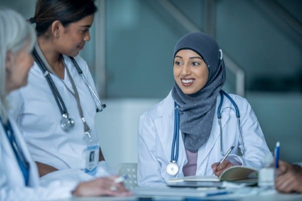A DNP discusses a patient with her colleagues.
