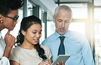 group of professionals looking at a tablet