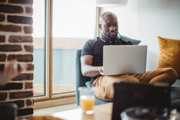 A man uses his laptop to research graduate school options