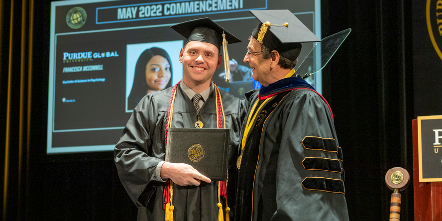 After completing a bachelor’s degree through Purdue University Global, Justin Marvin (pictured with Chancellor Frank Dooley) began pursuing a master’s degree in public administration. (Purdue University photo/John Underwood)
