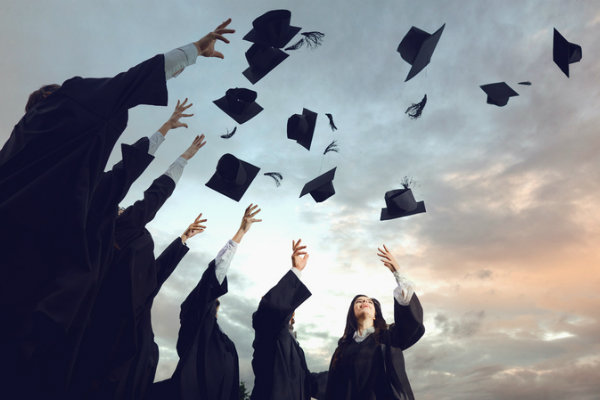 Graduation caps tossed into the sky by a crowd of graduates.