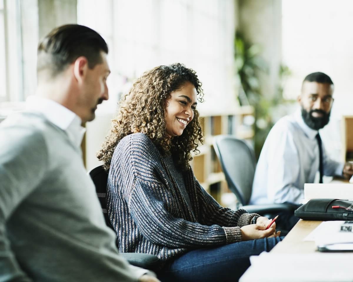 three professionals having a discussion in a conference room