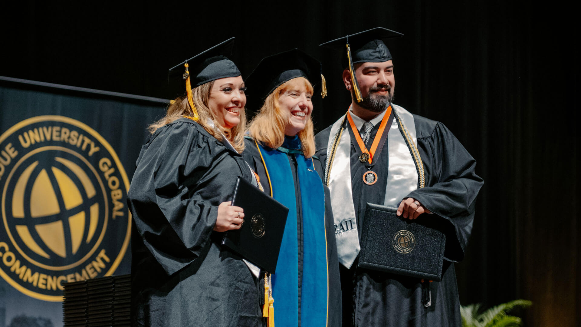 Rebecca and Caleb Ortiz accepting their diplomas at graduation