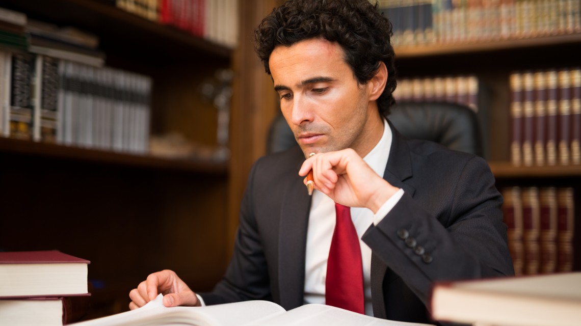 A lawyer reviewing legal texts in a law library.