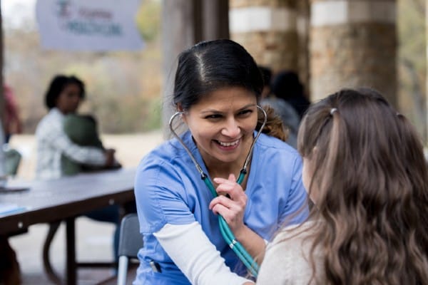 A community health nurse examines a young patient.