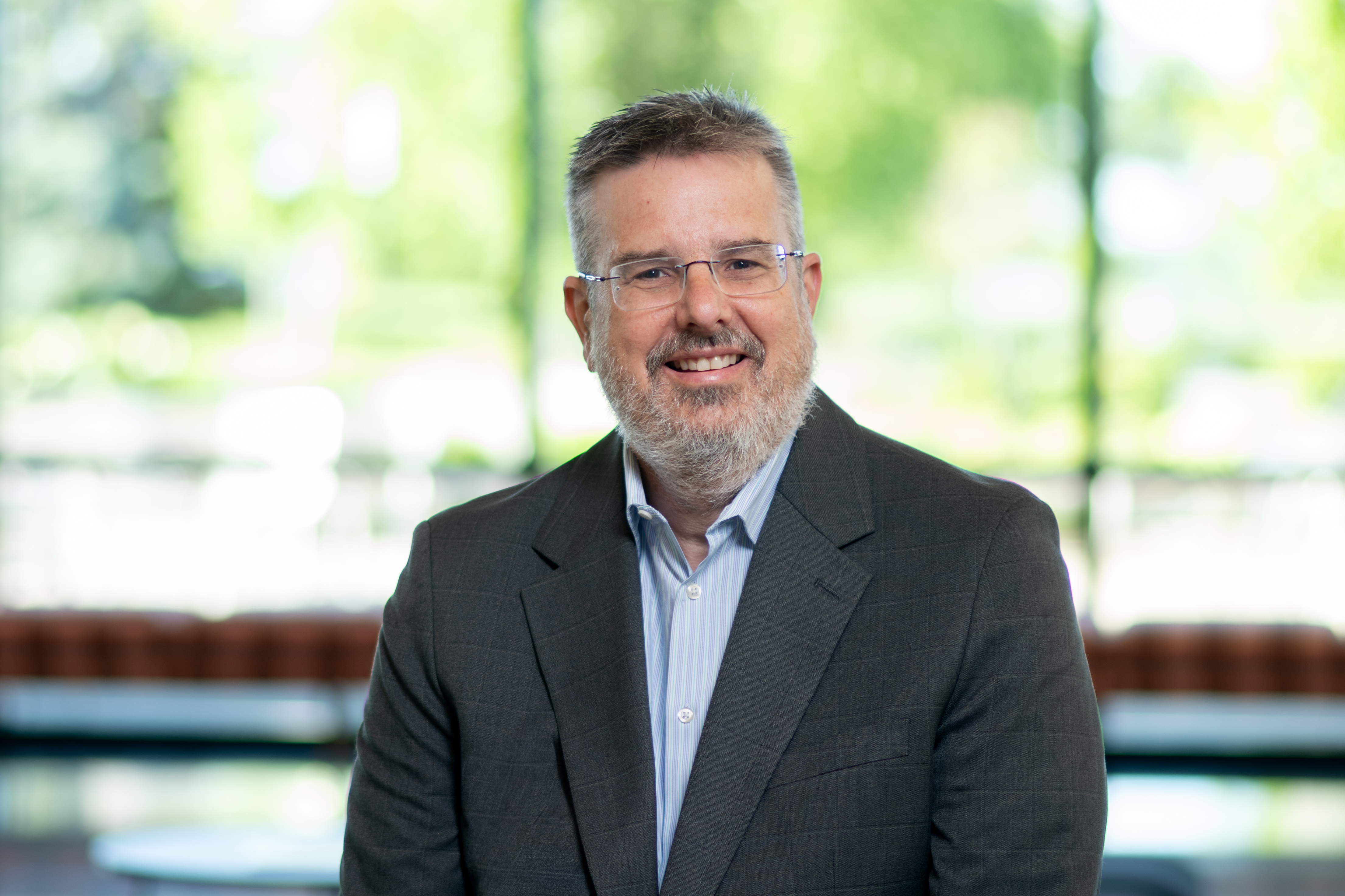 CAP: John Higgins’ new role as Purdue Global’s chief transformation officer puts him in charge of the online university’s project planning and innovation initiatives. (Purdue Global photo/John Underwood)
ALT: A man in a black jacket in an office.