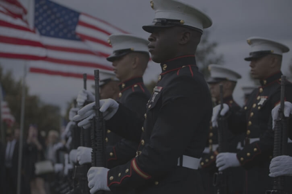 marines in dress blues holding rifles in front of an american flag