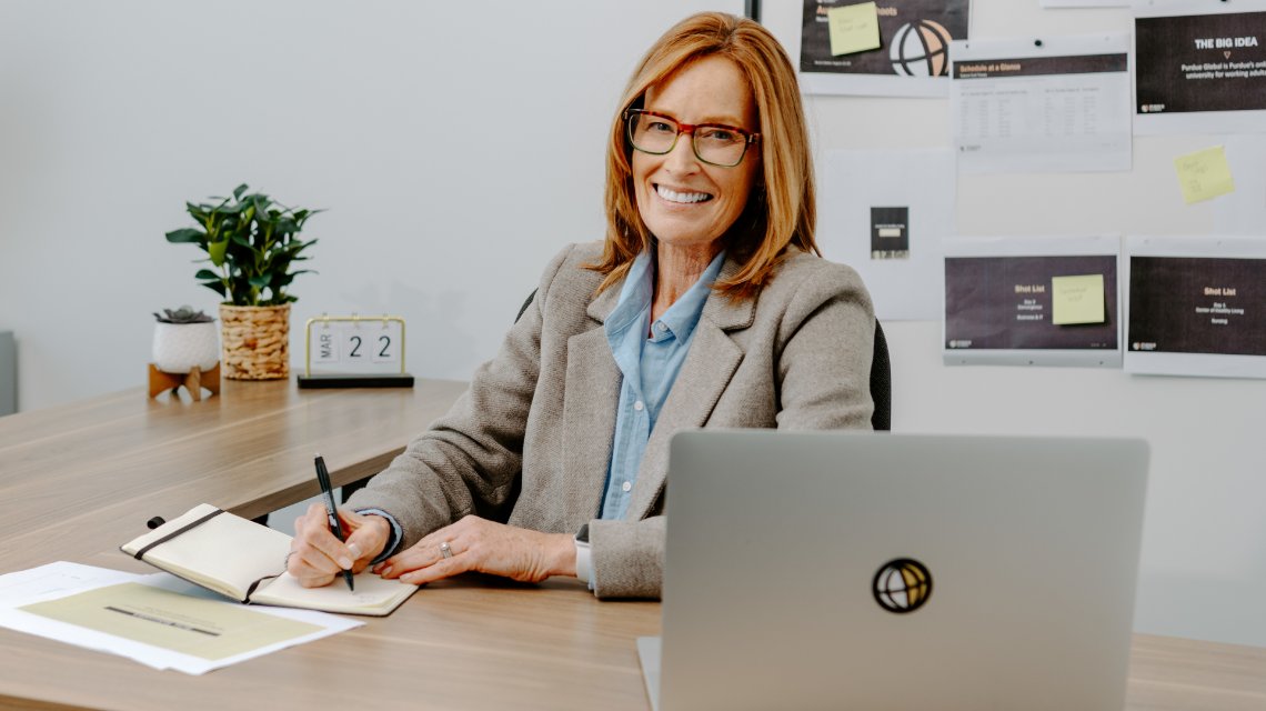 A woman is working at her desk in an office.