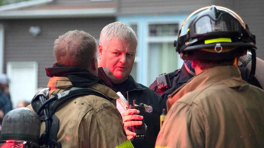 Robert Wilson speaks to firefighters in uniform