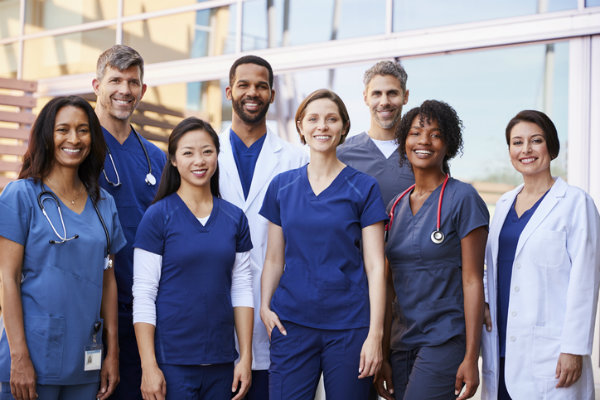A group of nurses stand outside a hospital