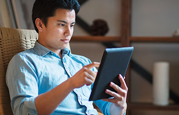 Man reclining in chair looking at tablet