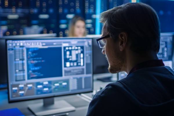 A systems analyst watches data from his laptop.