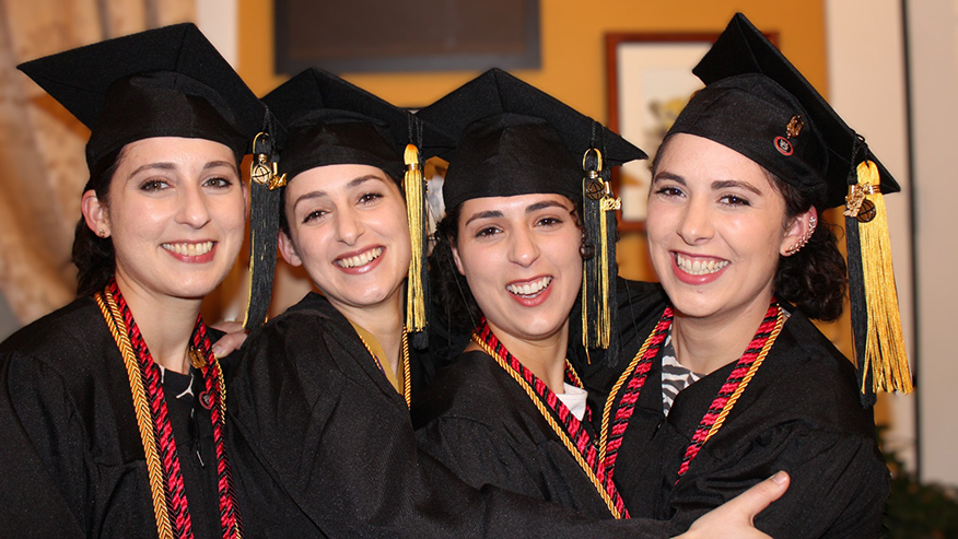 The Minaise sisters smiling in their caps and gowns