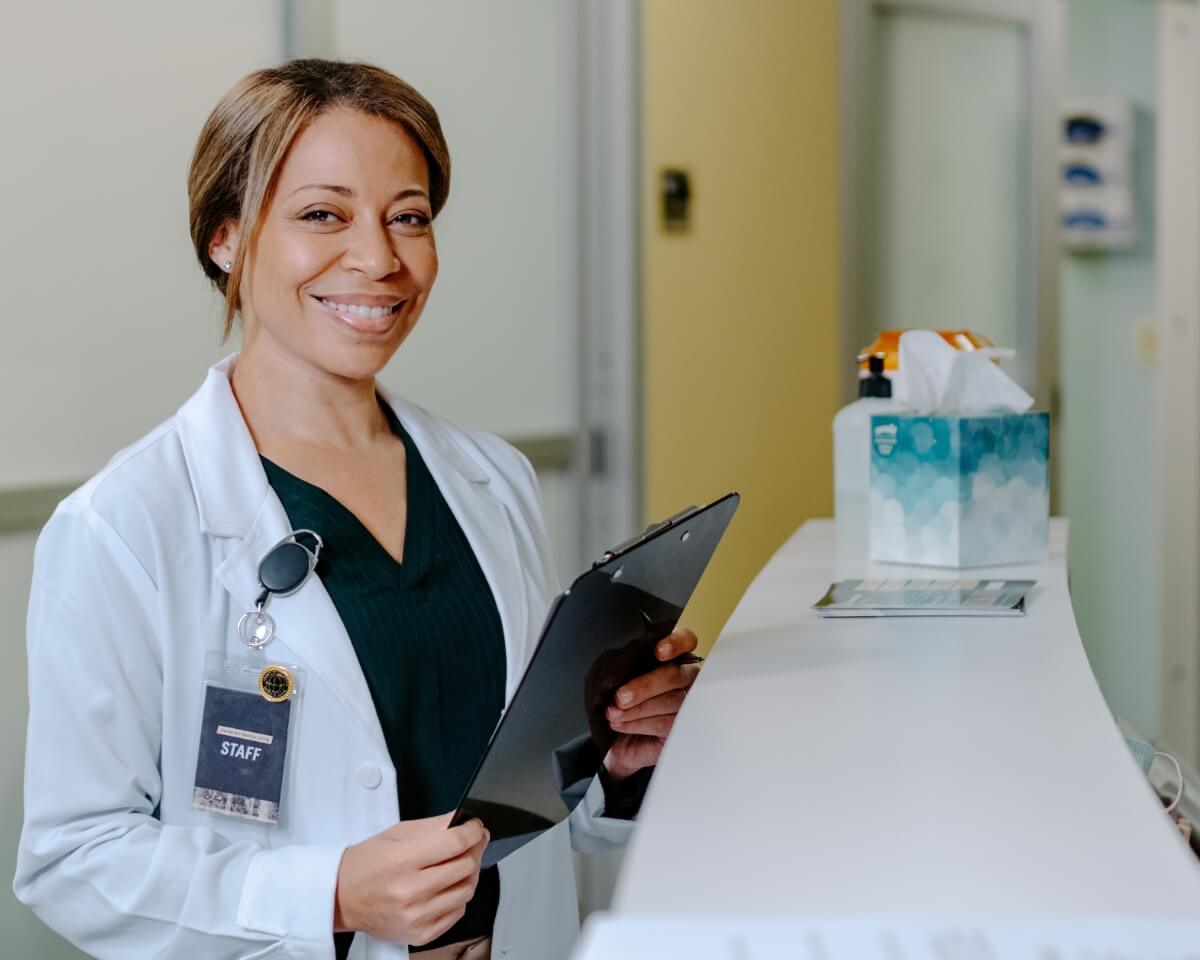 Nurse practitioner in white lab coat holds a medical chat at a nursing station