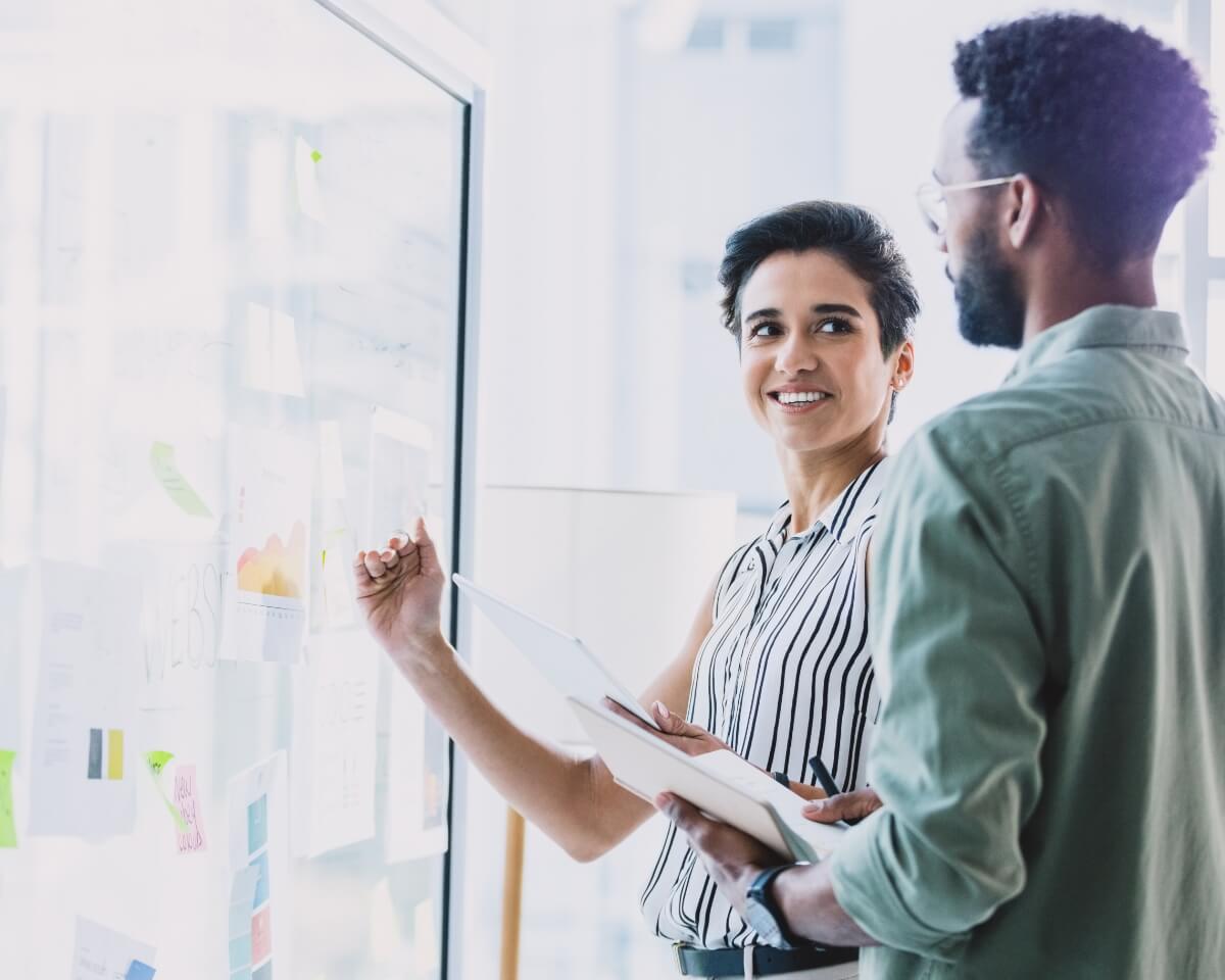 professionals discussing charts on a screen in a bright office