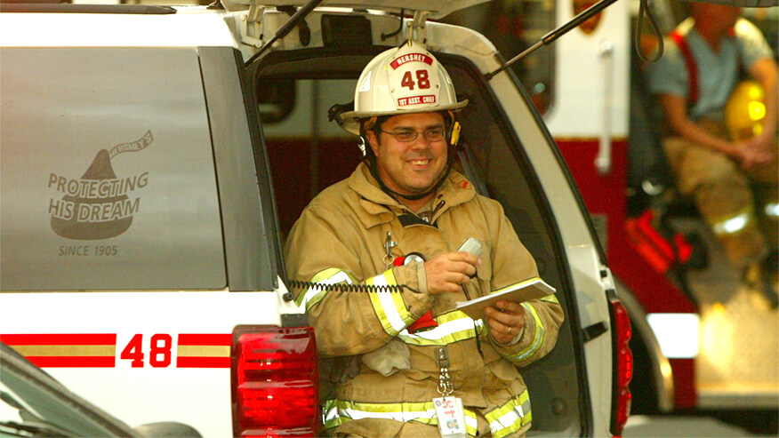 Purdue Global fire science faculty members like Rodney Sonderman sitting in a Fire SUV talking on the radio.