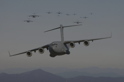 Military cargo planes flying over mountains