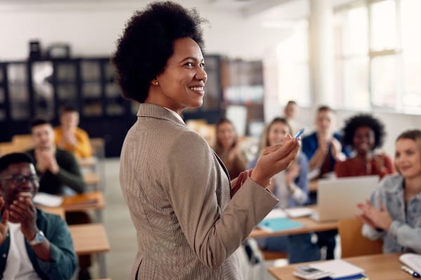 A woman stands in front of a classroom filled with students