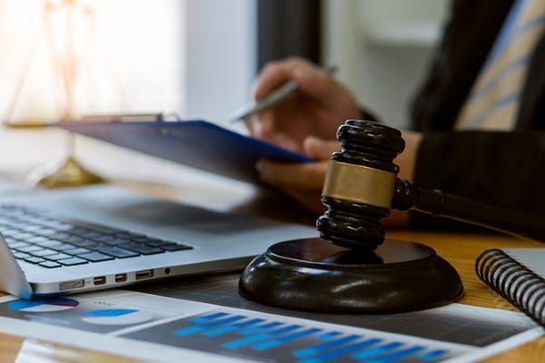 A lawyer works at a desk with a judge’s gavel nearby