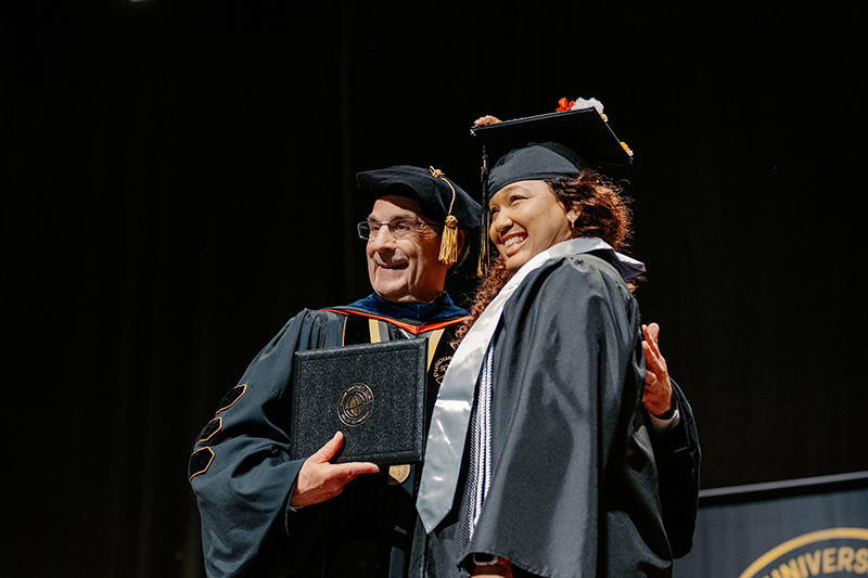 Purdue Global Chancellor Frank Dooley celebrates with a student during a spring commencement ceremony at Elliott Hall of Music on Purdue University’s West Lafayette campus on May 4.
