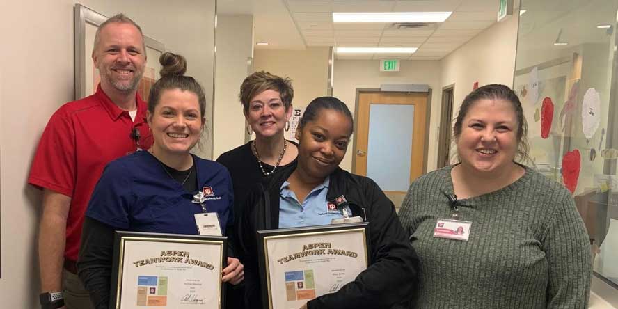 Marshall poses with her team at work, displaying their awards. (Photo provided)