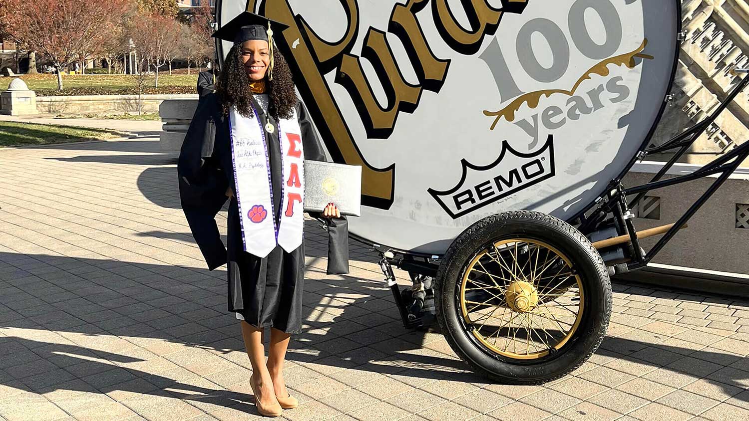 Purdue Global alumna and commencement speaker Nicole Richardson Hicks of Wellington, Florida, holds her degree next to the World’s Largest Drum in 2021. (Photo provided)