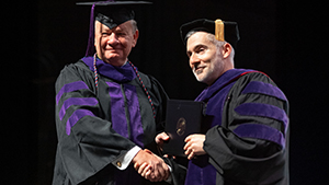 Nelson A. Locke shakes hands with Purdue Global Law School Dean Martin Pritikin during the February 2023 Purdue Global commencement ceremony. (Purdue Global photo/Jon Garcia)